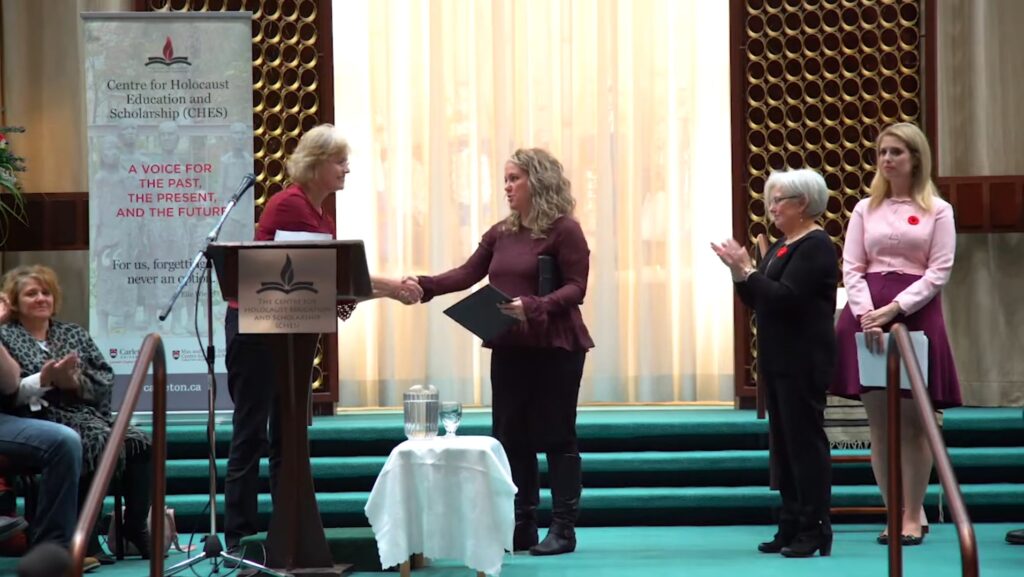 Award recipient shaking hands with the presenter on stage